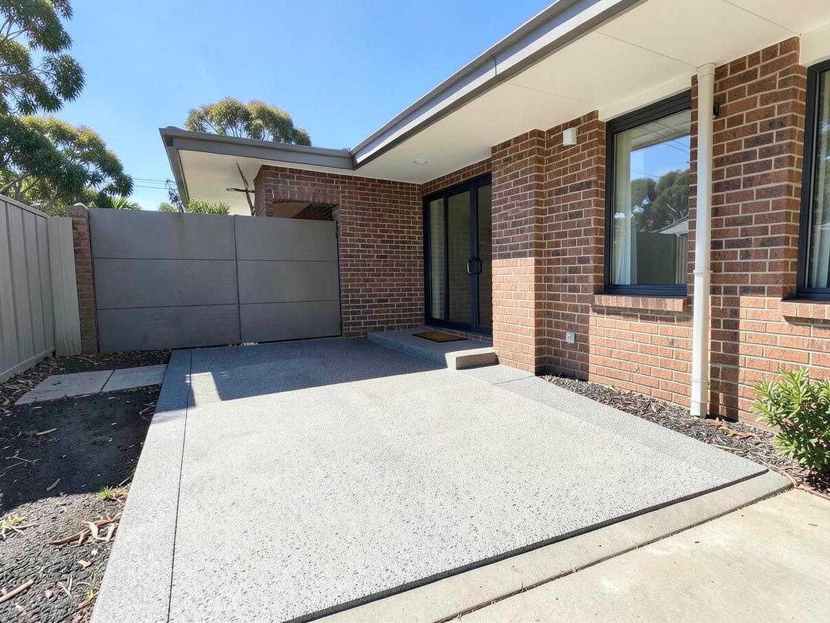 Finished exposed aggregate concrete driveway at an Australian brick home